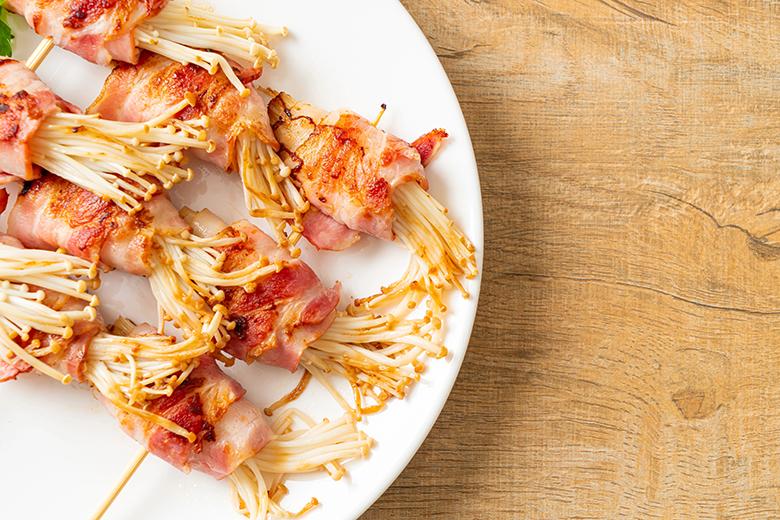 Enoki-Pilze im Speckmantel