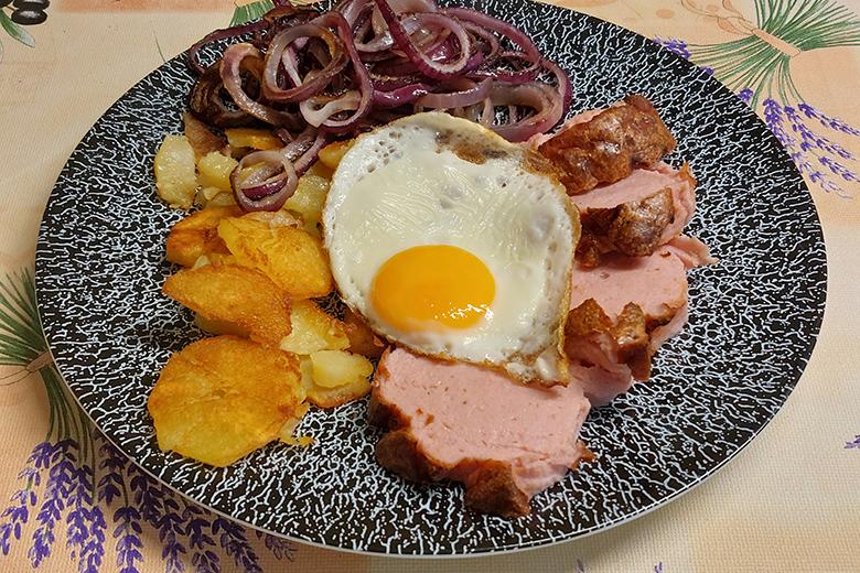 Leberkäse mit Spiegelei und Zwiebeln
