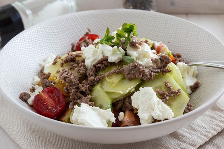 Salat mit Tomaten, Gurken, Hackfleisch und Feta