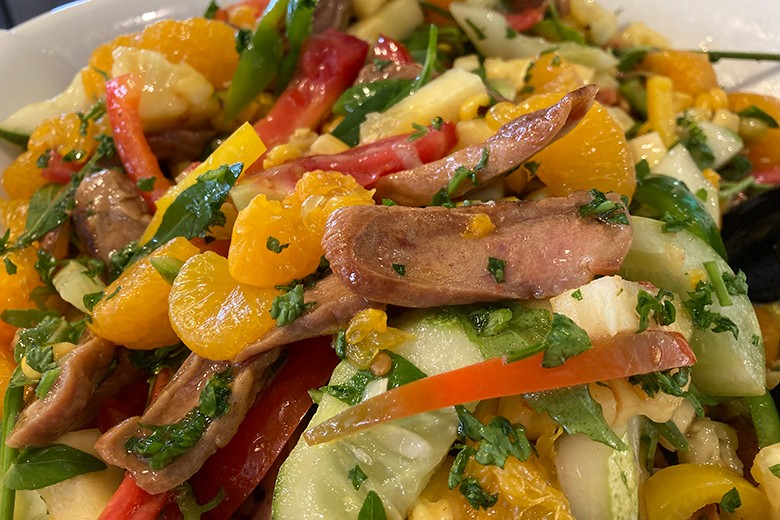 Fruchtiger Salat mit gebratenen Würstchen