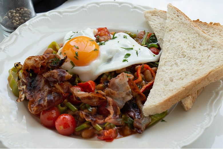Deftiges Frühstück mit Bohnen, Speck und Spiegelei