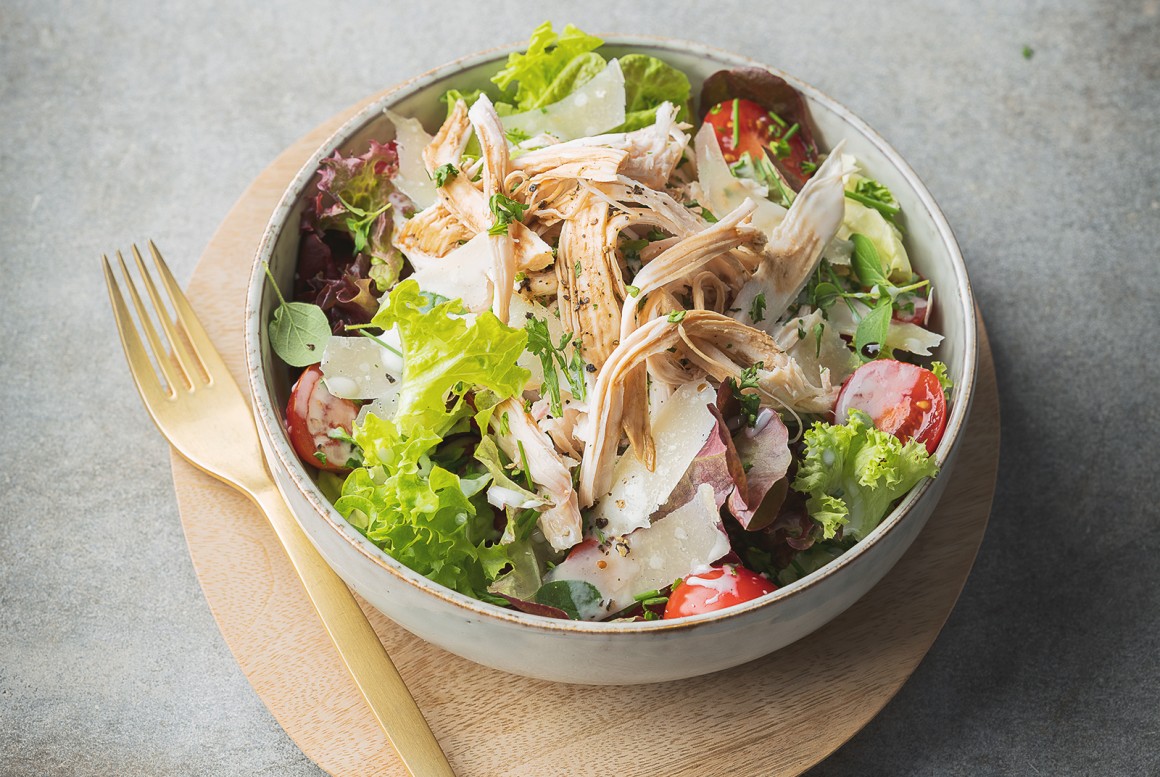Pulled Chicken auf grünem Salat mit Kräuterdressing und Parmesan
