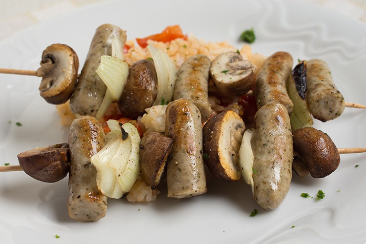 Bratwurst-Spieße auf Tomatenreis mit Champignons