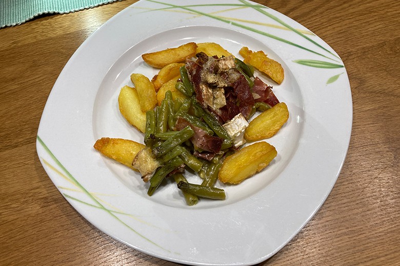 Speckbohnen mit Käse auf Kartoffeln