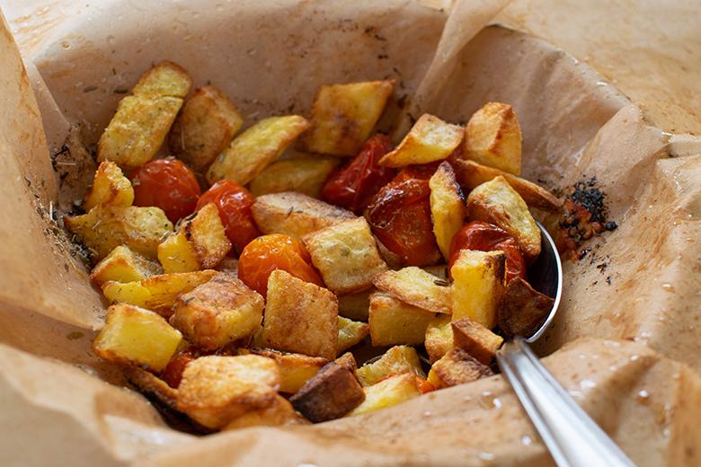 Knusprige Kartoffelstücke mit Tomaten aus dem Ofen