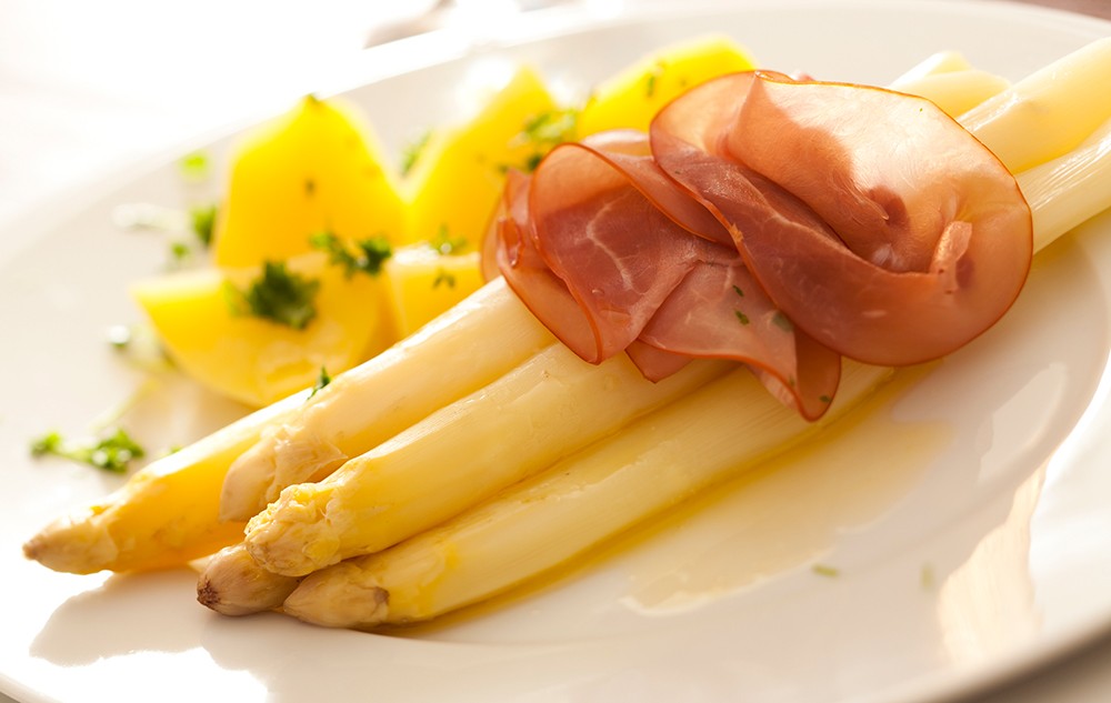 Spargel kann klassisch mit Schinken und Kartoffeln serviert werden.