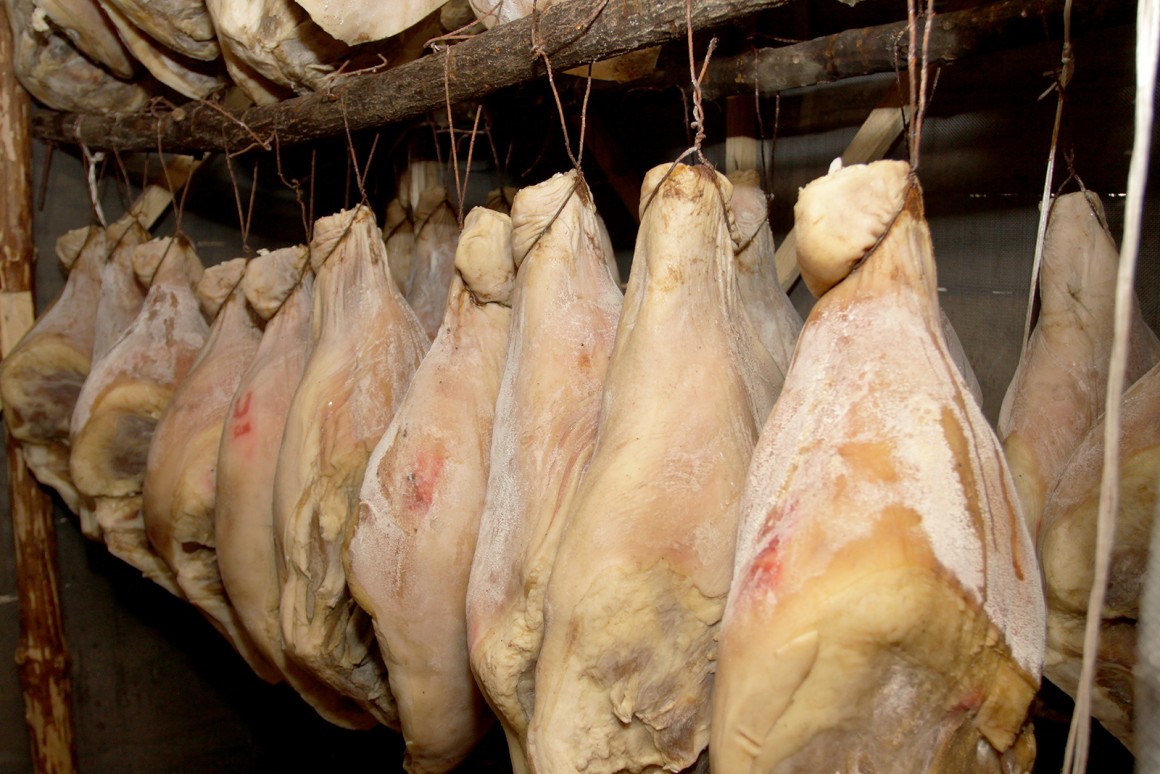 Bei der Herstellung von Prosciutto wird das Fleisch mit Meersalz eingepökelt und in dunklen Räumen eingelagert.