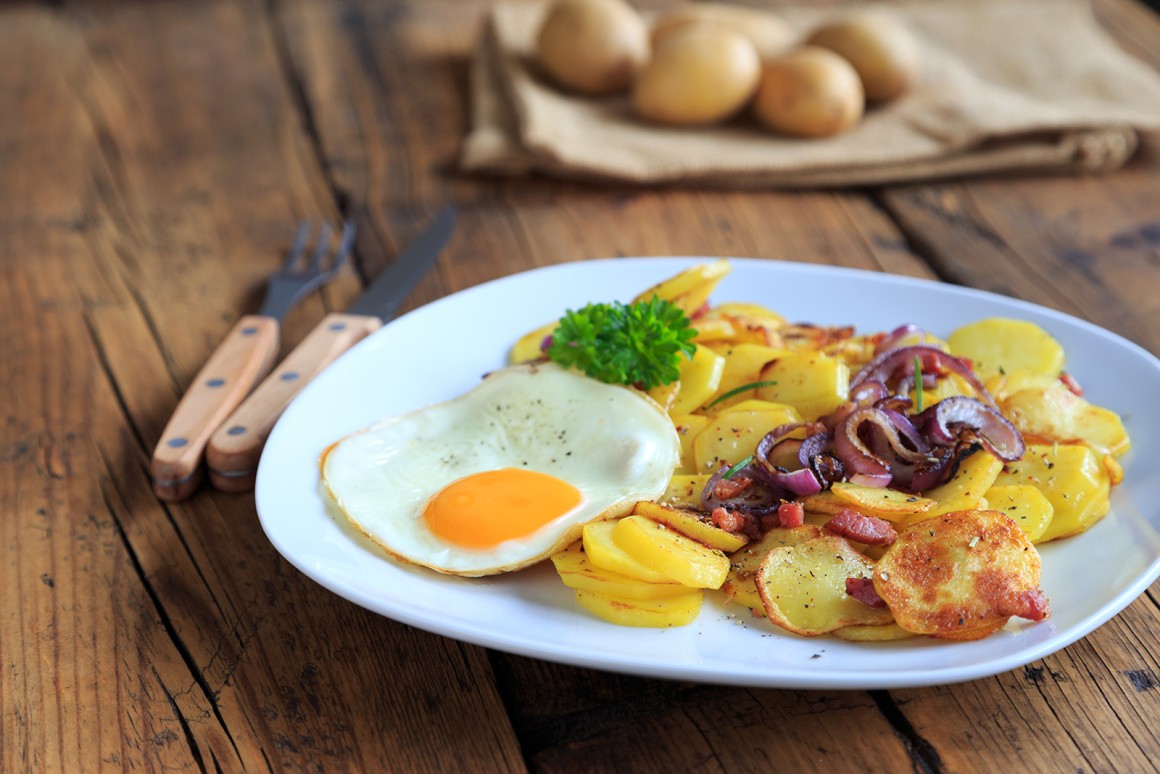 Spiegelei auf Bratkartoffeln mit Zwiebeln - Rezept | GuteKueche.de